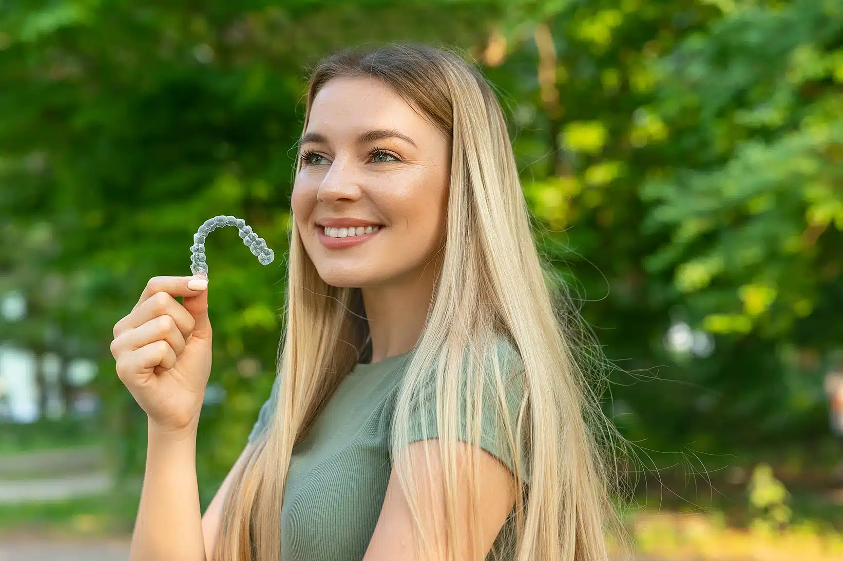 Smiling woman with perfect and healthy teeth using removable bra clear aligner blog Trail West Family Dentistry in Greenville, SC